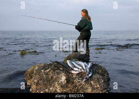 Pescatore femmina con catturato Aguglia (Belone belone), Germania Foto Stock