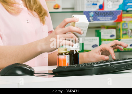 Il farmacista femmina la preparazione di Bill Foto Stock