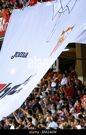 Sevilla FC fans facendo un tifo con una gigantesca camicia. Foto Stock