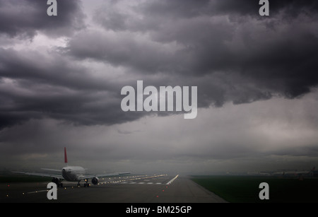 Piano pronto a decollare e tempestoso cieli, l'aeroporto di Heathrow di Londra, Inghilterra, Regno Unito, Europa Foto Stock