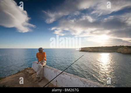 Pescatore sulla cima di una scogliera, città di portici, comune di Lagoa, distretto di Faro, regione di Algarve, PORTOGALLO Foto Stock