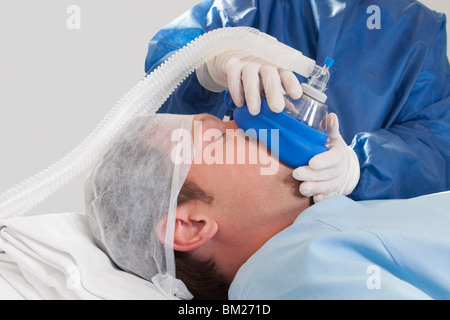 Medico anestetizzante un paziente in sala operatoria Foto Stock