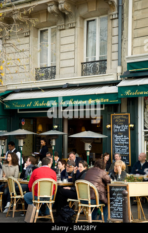 La gente seduta al di fuori di un cafè sulla Ile Saint Louis, Parigi, Francia Foto Stock