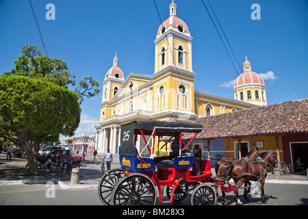 Carrello cavallo passando Cattedrale de Granada, Parco Colon (Park Central), Granada, Nicaragua Foto Stock