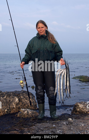 Pescatore femmina con catturato Aguglia (Belone belone), Germania Foto Stock