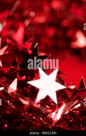 Stella di Natale decorazioni di carta ancora allo studio sfondo rosso Foto Stock