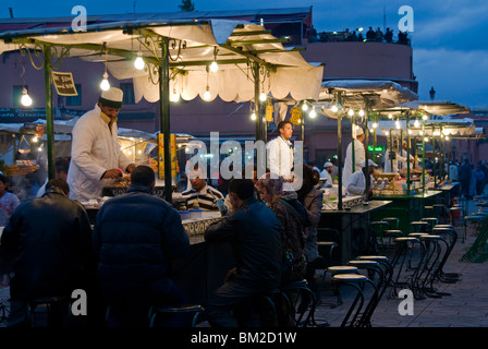 I cuochi di vendita di alimenti da loro stalle in Djemaa el Fna Piazza Jemaa el Fna (Djemaa el Fna), a Marrakech (Marrakech), Marocco Foto Stock