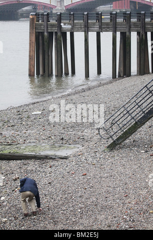 L uomo alla ricerca di roba sulla spiaggia Thames South Bank Millennium modo Blackfriars Londra Inghilterra Regno Unito Regno Unito Foto Stock