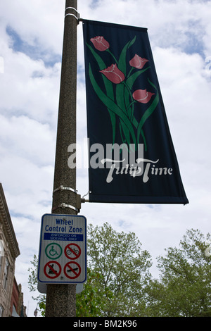 Tulip Time Festival Olanda Michigan negli Stati Uniti bandiera del Tulip Time Festival con logo montato sul palo di attraversamento della strada sopra il cartello di controllo ruote ad alta risoluzione Foto Stock