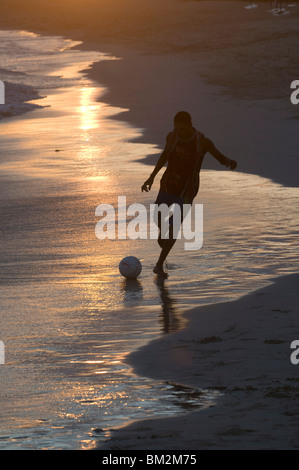 Giovane uomo giocando a calcio a sandbeach in Twilight, Santa Maria, Sal, Capo Verde Foto Stock