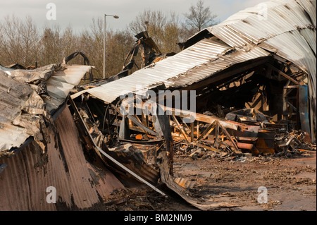 Fuso bruciato twisted metal travi di acciaio dopo il magazzino incendio in fabbrica Foto Stock