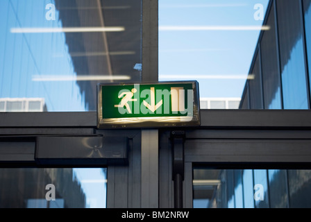Uomo che corre uscita di emergenza segno sulla porta Foto Stock