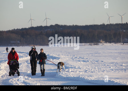 Persone e famiglie attraversano il porto orientale su una strada ghiacciata sul mare in inverno profondo a Mariehamn Åland Finlandia Foto Stock