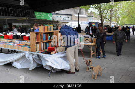 Uomo con due cani esplorazione del libro si spegne sul South Bank di Londra city centre REGNO UNITO Foto Stock