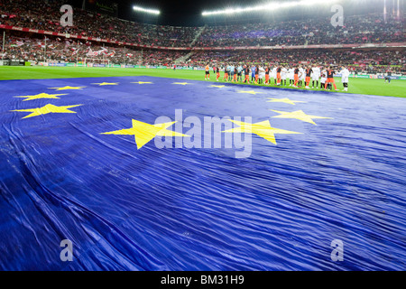 Sevilla FC e Valencia CF giocatori stringono le mani di fronte a una grande bandiera europea sul campo prima di una partita Foto Stock