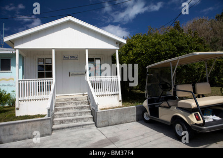 I pittoreschi edifici dipinti del Post Office con un golf cart, il solo modo di trasporto su Man o War Cay nelle Bahamas. Foto Stock