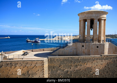 Una vista del Grand Harbour dalla parte inferiore Barracca Gardens. Una grande nave da carico è la vela fuori con l'Assedio campana destra Foto Stock