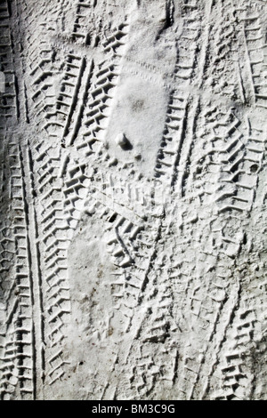 Pneumatici stampa stampe vie neve invernale tireprints tiretracks coperto congelati a sinistra della strada di attraversamento trasversale illeggibili Foto Stock