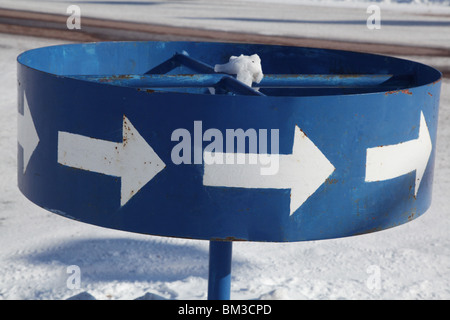 FRECCE SIMBOLICHE SULLA MINI ROTATORIA: Frecce sulla mini rotatoria rotatoria rotatoria rotatoria innevata Finlandia Svezia inverno Foto Stock