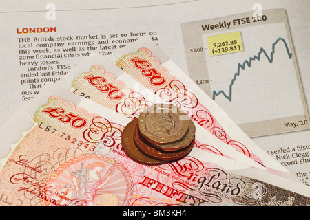 Valuta britannica, Sterling Pound, su un foglio di stock che mostra il London Stock Market FTSE grafico. Foto Stock