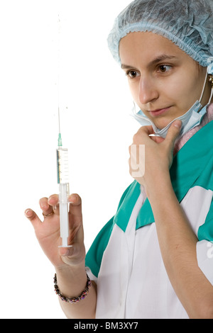 Donna un medico in uniforme guarda una siringa piena, isolato su bianco Foto Stock