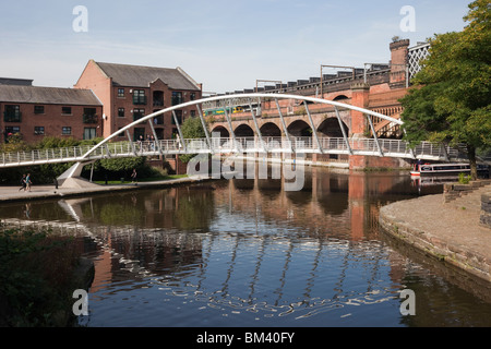 Manchester, Inghilterra, Regno Unito. Mercantile del moderno ponte passerella su Bridgewater Canal in Castlefield Urban Heritage Park Foto Stock