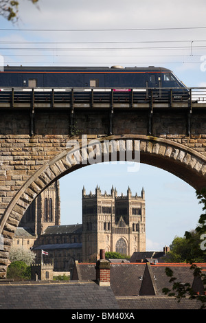 Un East Coast treno passeggeri passa la Cattedrale di Durham visto attraverso un arco del viadotto ferroviario, Durham City, Inghilterra. Foto Stock