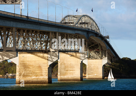 Una barca passa sotto la Auckland Harbour Bridge. Auckland, Isola del nord, Nuova Zelanda Foto Stock