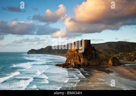 Piha Beach e Lion Rock al tramonto. Piha, Waitakere gamme Parco Regionale, Auckland, Isola del nord, Nuova Zelanda Foto Stock