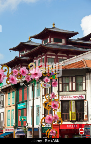 Colorate botteghe con il Dente del Buddha reliquia tempio in background. Chinatown, Singapore Foto Stock