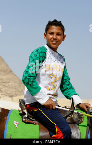 Ragazzo giovane sul suo cavallo, le Piramidi di Giza, Necropoli di Giza confinanti con che cosa ora è El Giza, Cairo , Egitto Foto Stock