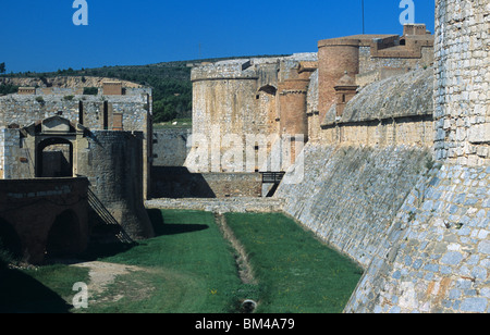 Fossato asciutto, Ingresso & mura difensive o fortificazioni di Salses fortezza o Fort (c15th) vicino a Perpignan, a sud ovest della Francia Foto Stock