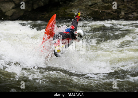 Un kayaker riproduce in un foro nella gola Tariffville sul fiume Farmington nella classe III whitewater pale a mano Foto Stock