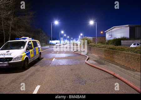 Tubo antincendio e auto della polizia in strada di notte Foto Stock