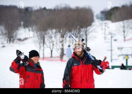 Un uomo e una donna a capo di piste a Quechee Ski Hill in Quechee, Vermont. Foto Stock