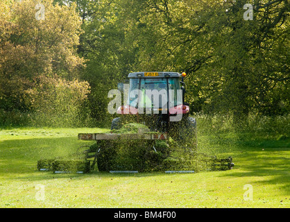 Un trattore la falciatura di erba lunga sui campi a Colwick boschi in NOTTINGHAM, NOTTINGHAMSHIRE REGNO UNITO Inghilterra Foto Stock