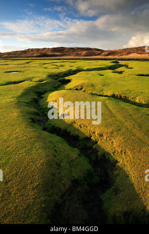 Serata di modelli di luce una drammatica frattura nella palude salata dove il fiume Ogmore incontra il mare nel Galles del Sud Foto Stock