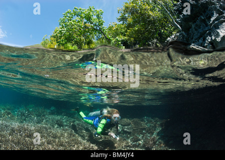 Lo snorkeling a shallow Coral Reef, Raja Ampat, Papua occidentale, in Indonesia Foto Stock