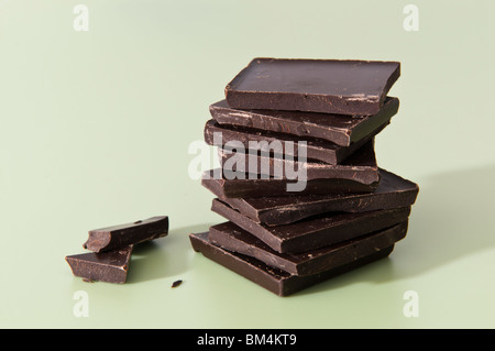 Studio shot di una pila di cioccolato fondente a pezzi contro uno sfondo bianco Foto Stock