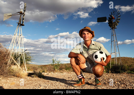 Un agricoltore del Sud Africa in una fattoria rurale con pallone da calcio in attesa per la coppa del mondo di calcio Foto Stock