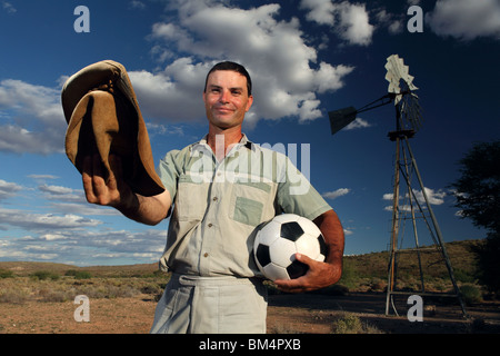 Un agricoltore del Sud Africa in una fattoria rurale con pallone da calcio in attesa per la coppa del mondo di calcio Foto Stock