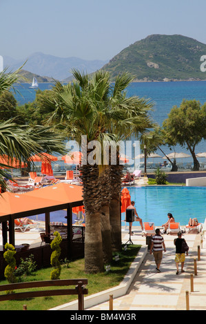 I villeggianti rilassarsi intorno a una piscina in albergo nella località balneare di Turgutreis vicino a Bodrum Turchia Foto Stock