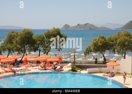 I villeggianti rilassarsi intorno a una piscina in albergo nella località balneare di Turgutreis vicino a Bodrum Turchia Foto Stock