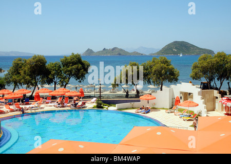 I villeggianti rilassarsi intorno a una piscina in albergo nella località balneare di Turgutreis vicino a Bodrum Turchia Foto Stock