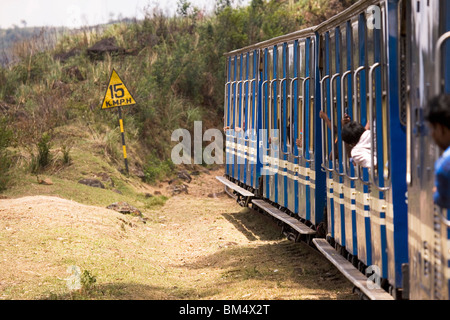 La carreggiata stretta Nilgiri ferrovia di montagna trundles lungo la via che si arrampica il Nilgiri Hills in India. Foto Stock