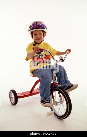 4 anno vecchio ragazzo in posa sul suo triciclo. Foto Stock