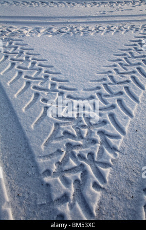 TRACCE GRAFICHE DEGLI PNEUMATICI IN NEVE INVERNALE PROFONDA: Cingoli degli pneumatici in neve vergine durante la notte da veicoli pesanti in Finlandia Foto Stock