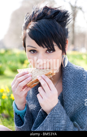 Giovane donna mangiare supermercato sandwich, England, Regno Unito Foto Stock