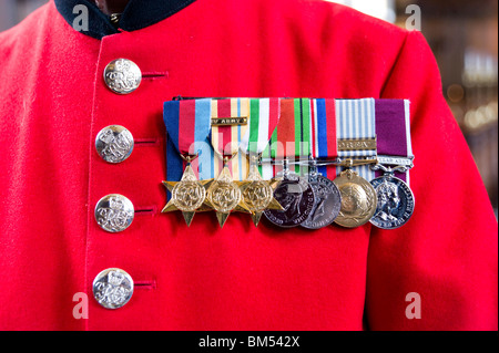 Le medaglie di guerra su scarlet cappotto di In-Pensioner John Ley presso il Royal Hospital Chelsea a Londra, in Inghilterra, Regno Unito Foto Stock