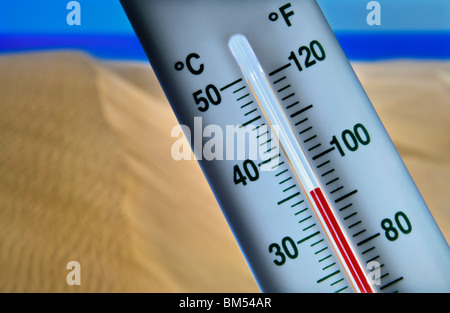Il Termometro visualizza 34 gradi centigradi contro il caldo secco e soleggiato costiere dune di sabbia di mare e cielo blu Foto Stock